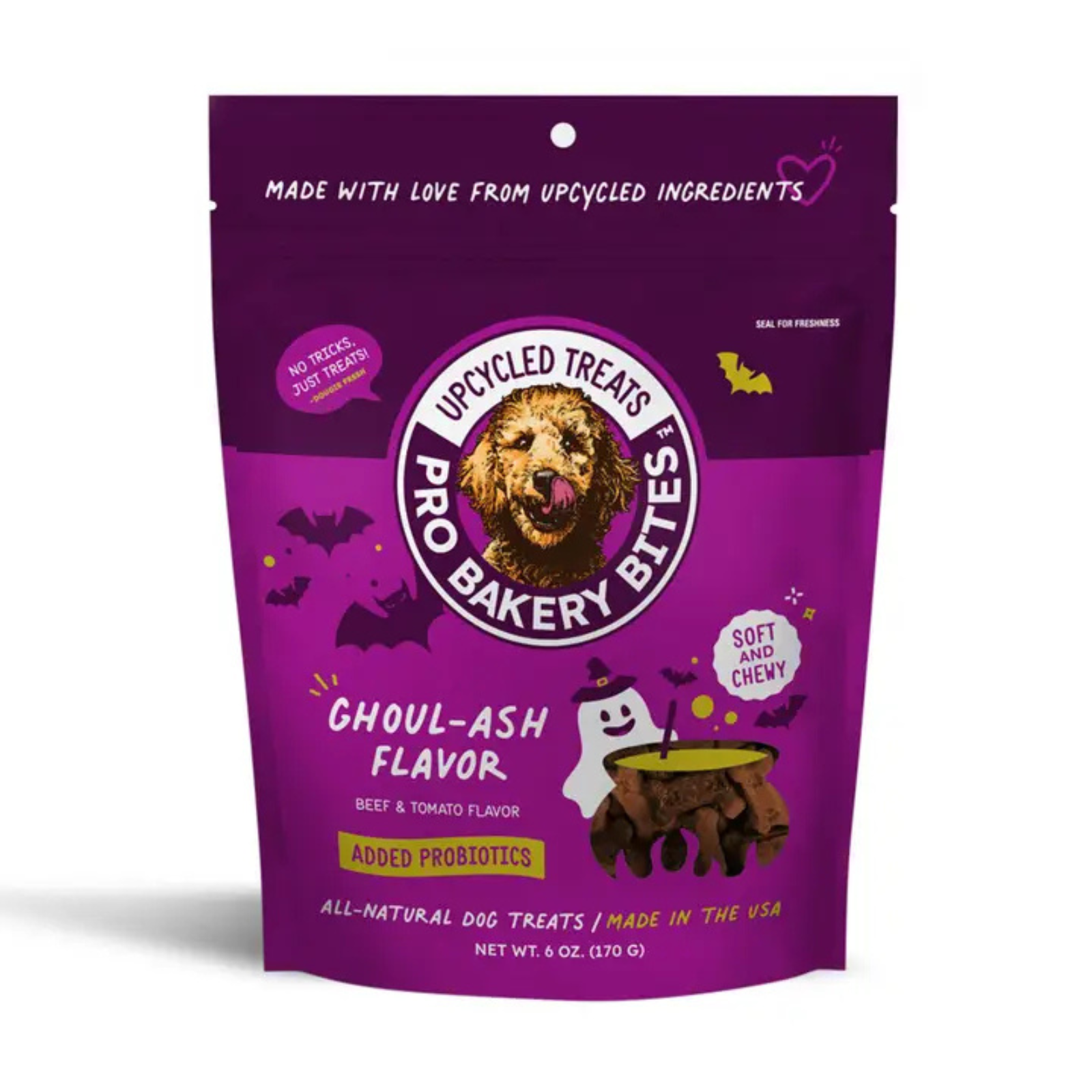 A purple stand-up pouch of Pro Baked by Upcycled Treats Ghoul-Ash Flavor dog treats, featuring a cartoon dog face logo and Halloween-themed graphics including a ghost, witch hat, and cauldron on a white background.