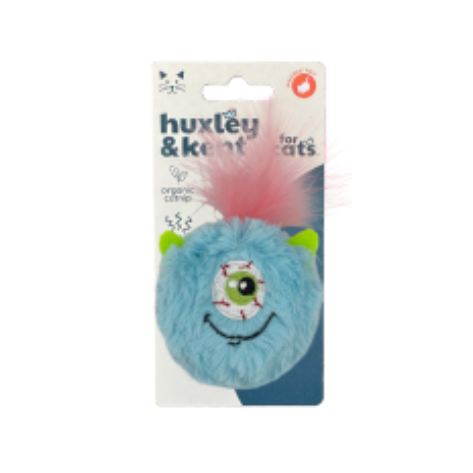 A Huxley & Kent 'for cats' plush toy attached to its retail card packaging. The toy is a round, fuzzy light blue monster with a single large stitched eye, a black smiley, green ears, and a fluffy pink tail.