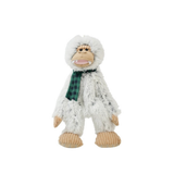 A plush toy of a furry white creature resembling a Bigfoot or Yeti, wearing a green and black plaid scarf, standing against a solid white background.
