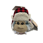 A plush toy monkey wearing a red and black plaid trapper hat with cream sherpa lining, shown on a white background with tags attached.
