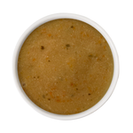 A top-down view of a thick, textured mustard-yellow or ochre-colored puree, such as pumpkin or squash mash, served in a white ceramic bowl against a solid white background.