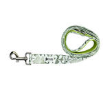 A dog leash with a green and white botanical pattern, a silver metal clasp, and a bright green inner lining, displayed on a white wood-textured background.