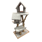 A multi-level cat tree with a house-shaped top perch, carpeted platforms, and natural wood legs and base, shown on a plain white background.
