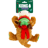 A Kong Cozie plush dog toy shaped like a reindeer, shown with its green branded hanging card. The toy is brown with a white face, a green and red patterned sweater, and a red scarf.