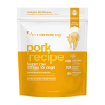 A stand-up pouch of Small Batch Dog 'Pork Recipe' frozen raw patties for dogs, featuring a white top half and a bright yellow-orange bottom half with product text and a dog silhouette illustration.