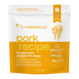 A stand-up pouch of Small Batch Dog 'Pork Recipe' frozen raw sliders for dogs, featuring a white and orange design with a graphic of a pig.