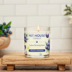 Pet House Candle labeled 'Wild Blueberries' on a wooden stand with a blurred background