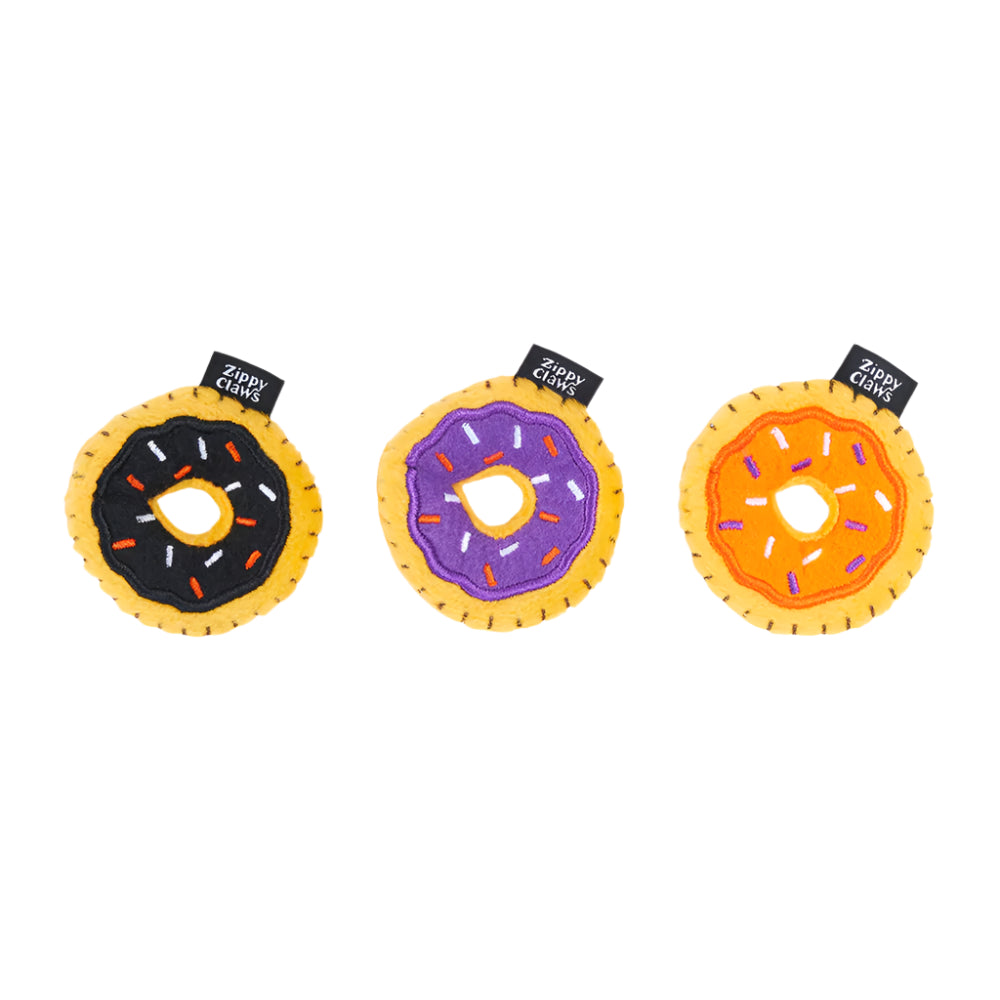 Three donut-shaped toys with colorful sprinkles on a white background