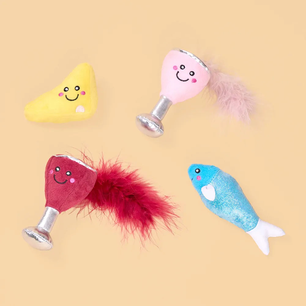 Four colorful cat toys on a beige background
