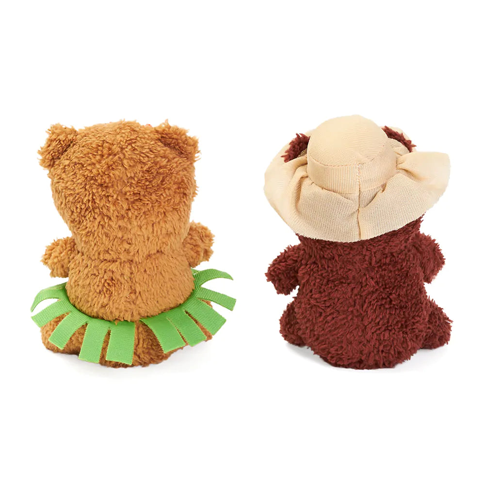 Two plush toys, one resembling a bear with a green skirt and the other resembling a lion with a beige mane, on a white background.