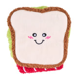 Toy resembling a sandwich with a smiling face on a white background
