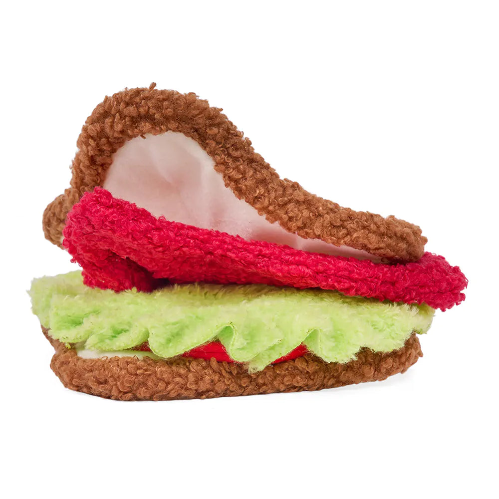 Plush toy resembling a burger with brown bun, red patty, and green lettuce on a white background
