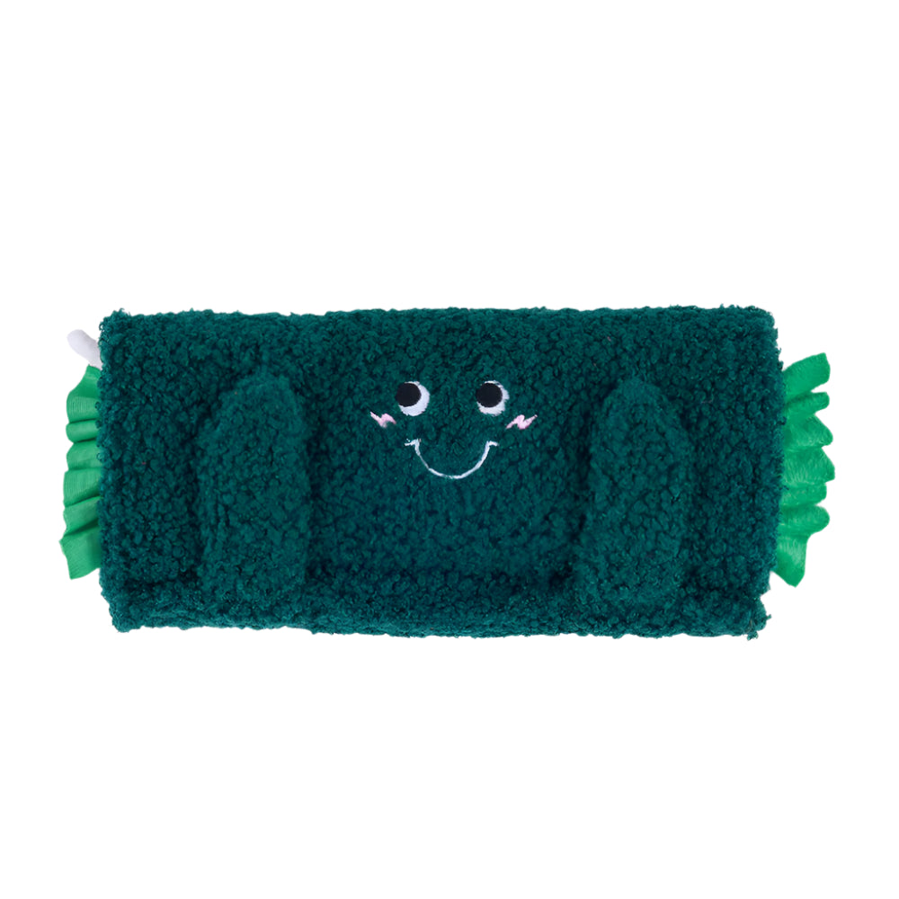 Green plush toy with a smiling face on a white background