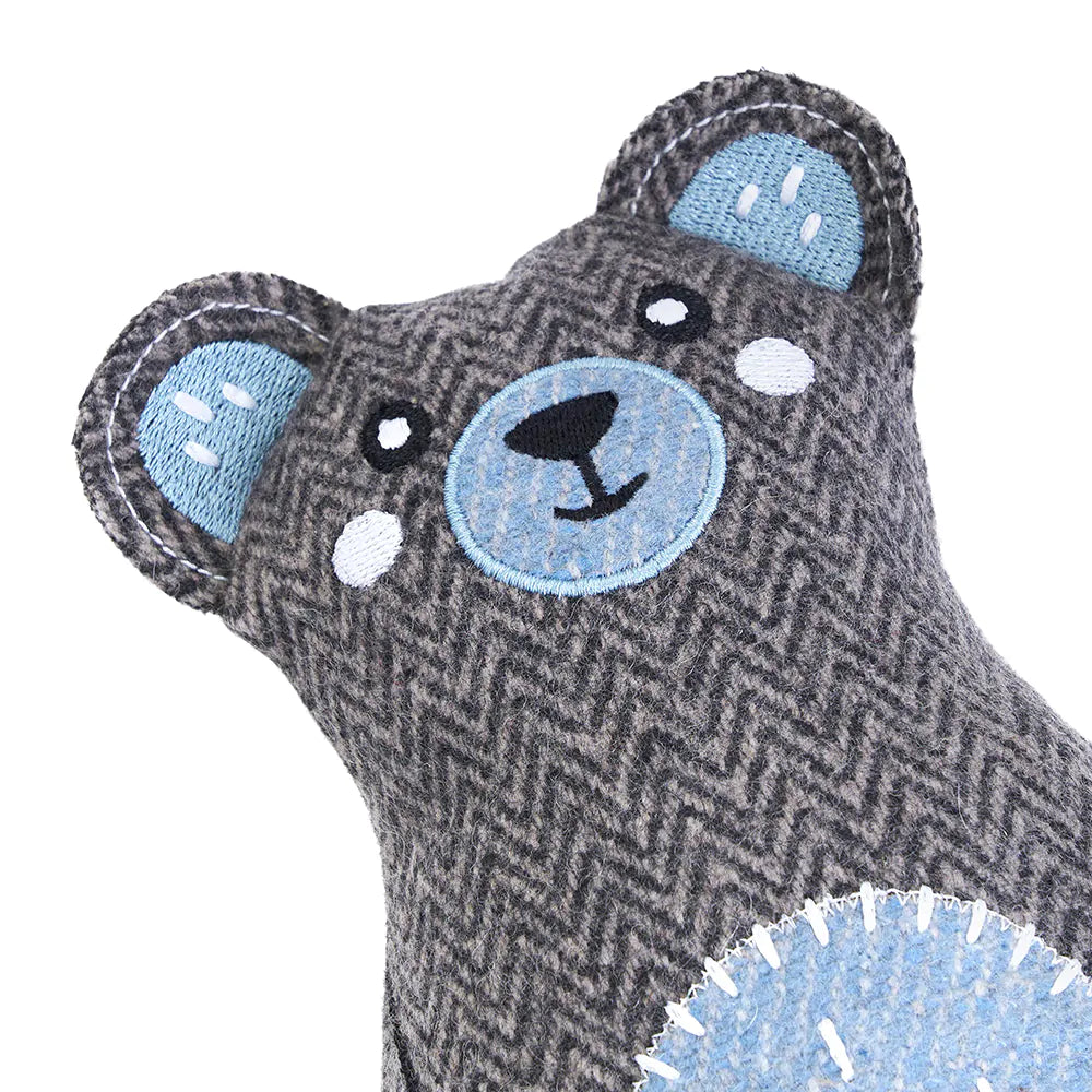 Gray teddy bear toy with blue accents on a white background
