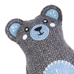Gray teddy bear toy with blue accents on a white background