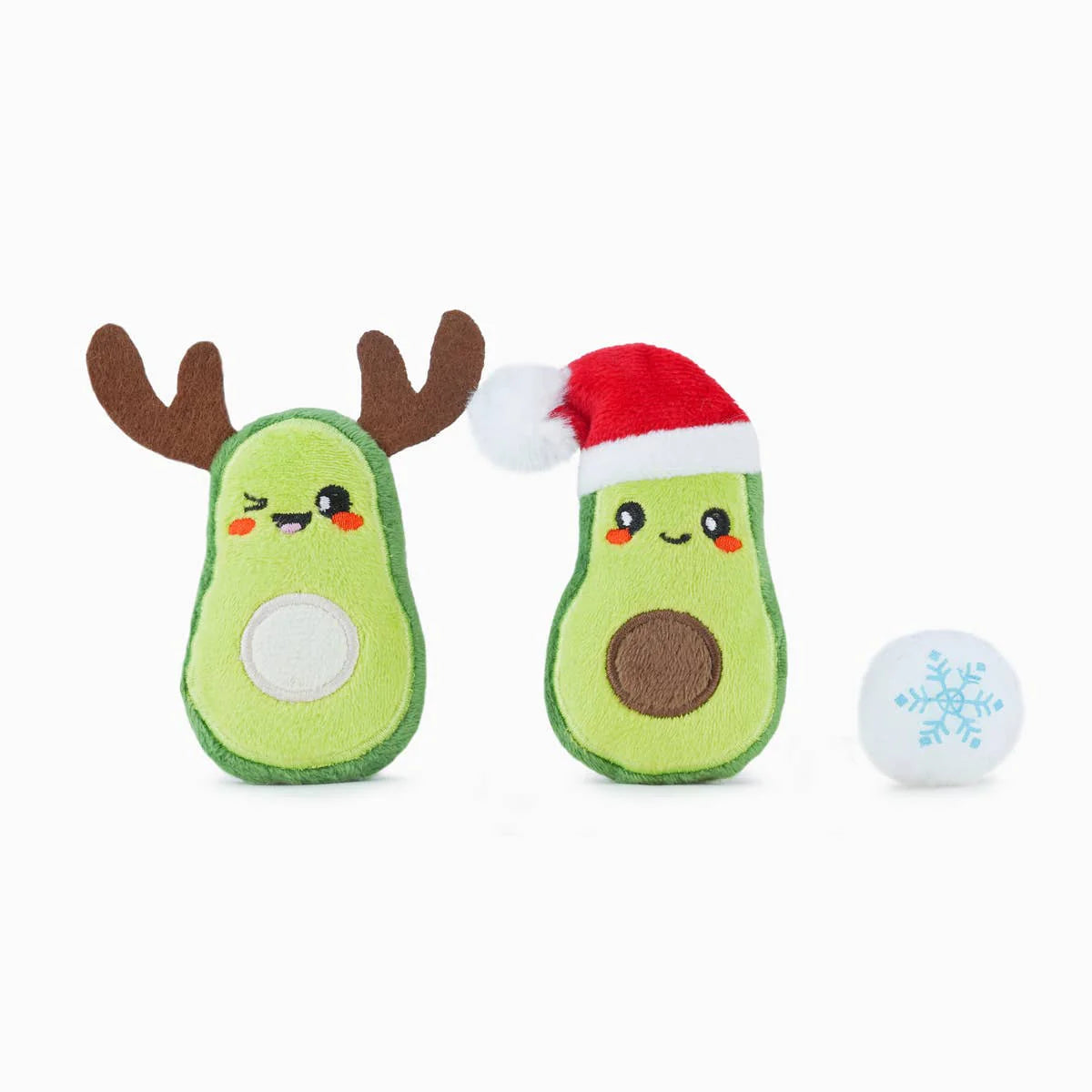 Two avocado-shaped toys with reindeer antlers and a Santa hat, accompanied by a small ball with a snowflake design on a white background.