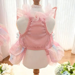 Pink pet dress on a mannequin with a white curtain background