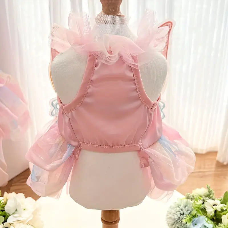Pink pet dress on a mannequin with a white curtain background