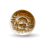 A round ceramic plate with a whimsical embossed design of a mushroom house, clouds, and plants in warm brown and cream tones, shown on a white background with a soft shadow.