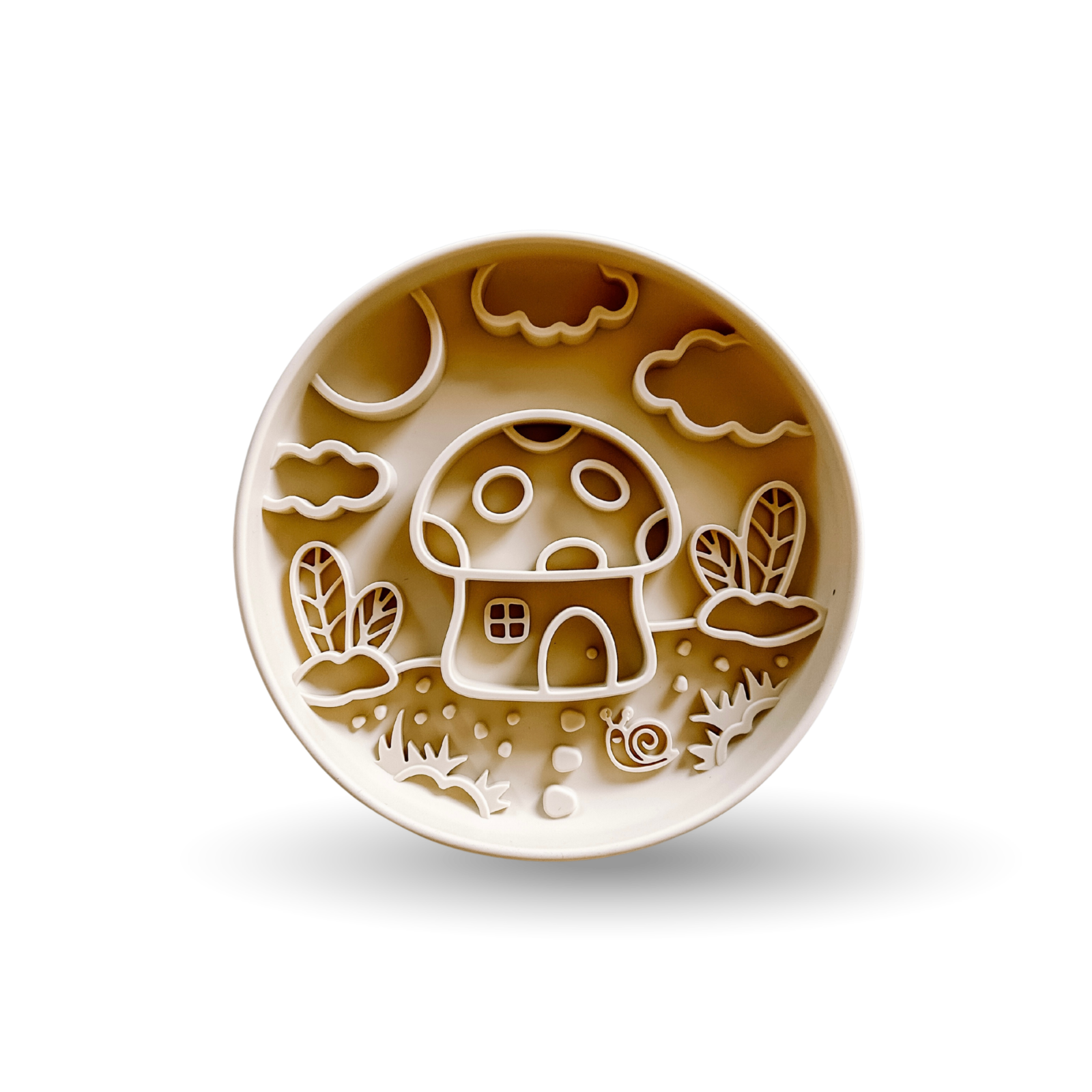 A round ceramic plate with a whimsical embossed design of a mushroom house, clouds, and plants in warm brown and cream tones, shown on a white background with a soft shadow.