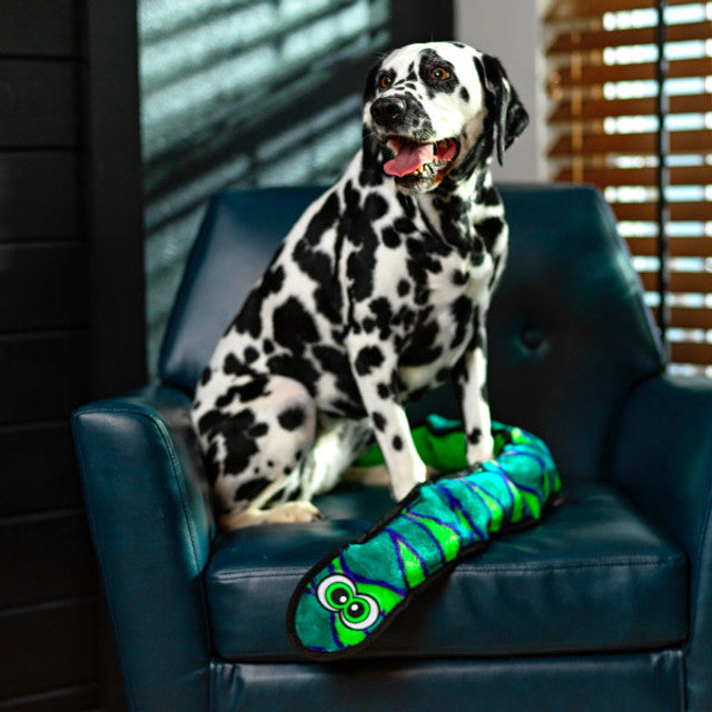Dalmatian dog sitting on a blue chair with a colorful toy.