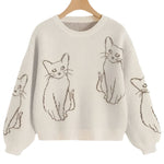 Beige sweater with cat illustrations on a white background
