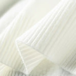 Close-up of a textured white fabric with a subtle pattern