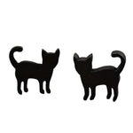 Black cat-shaped earrings on a wooden surface