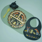 Pet's plate, bib, and spoon with nature-themed design on a light green surface