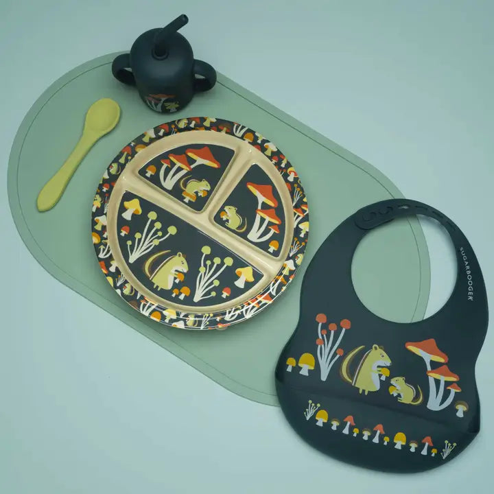 Pet's plate, bib, and spoon with nature-themed design on a light green surface
