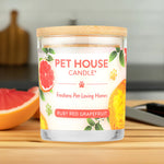 Pet House Candle labeled 'Ruby Red Grapefruit' on a wooden surface with a blurred background