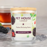 Pet House Candle labeled 'Blackberry Tea' on a wooden surface with a blurred background