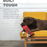 Dog chewing on a red toy with text about durability on a yellow couch.