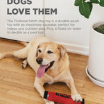 Dog playing with a FireHose Fetch toy on a wooden floor.