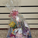 A Prefilled Easter Basket for small to medium dogs, containing various toys and treats, wrapped in clear plastic with a ribbon.