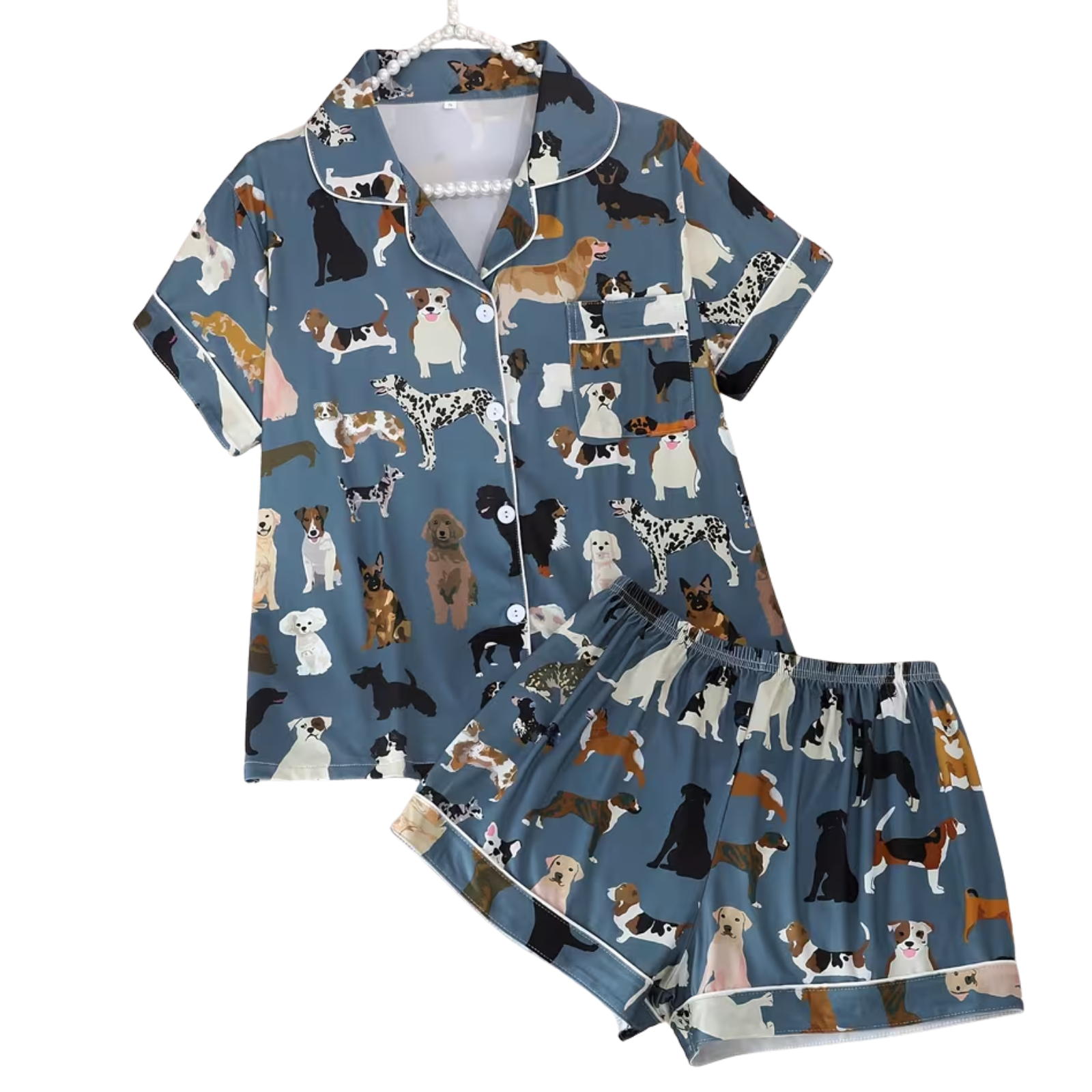 A two-piece pajama set featuring a short-sleeve button-front top and matching shorts in a dusty blue color, both printed with an all-over pattern of various dog breeds. The pajamas are shown on a white hanger against a plain white background.