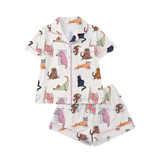 A two-piece pajama set featuring a short-sleeve button-front top and matching shorts in an off-white base with a colorful cartoon cat print, displayed on a clean white background.