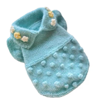 A light blue knitted pet sweater with a textured pom-pom pattern and small decorative flower embellishments, shown on a plain white background.