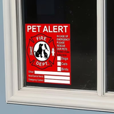 A red and white 'PET ALERT' window sign with a fire department-style emblem, shown attached to a dark window pane.
