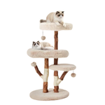 A multi-level cat tree with plush cream platforms, brown wooden posts, and hanging ball toys, shown with two cats resting on the levels against a plain white background.