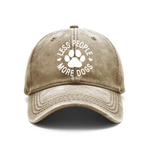 A tan denim hat with a white logo that reads "Less People More Dogs" with a pawprint in the middle displayed on a white background.