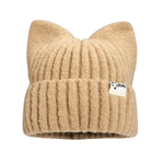 A tan colored knit hat with cat ears on the top and brand tag on the rim