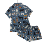 A two-piece short-sleeve pajama set featuring a blue base with an all-over print of various dog breeds, shown on a plain white background.