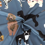 Blue fabric printed with various dog illustrations, gathered in the center to show the material's drape and sheen.