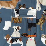 Close-up of a blue fabric garment featuring an all-over print of various dog illustrations and a matching front pocket.