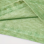 A close-up of a light green knit fabric with a folded corner showing a decorative wavy contrast stitch along the edge, set against a plain white background.