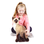 A child playing with a plush Siamese cat toy.