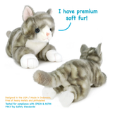 Two plush toy grey tabby kittens on a white background, one sitting and one lying down, with blue text reading 'I have premium soft fur!' and small safety certification text at the bottom.
