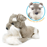 A plush dog toy styled like a gray and white Schnauzer, lying down on a white background. An inset circle at the top right shows a close-up of its realistic face with the text 'Realistic Face with Character!'.