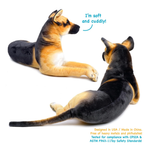 Two plush German Shepherd dog toys shown on a white background, one facing left and one facing right, with blue text reading 'I'm soft and cuddly!' and additional safety text in the lower right.